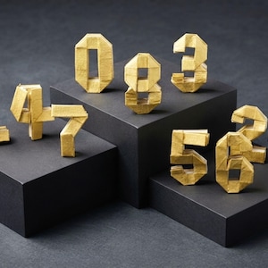 May include: A collection of ten three-dimensional numbers crafted from gold-colored paper, featuring the digits zero through nine. Each number is constructed with visible folded edges and geometric facets, standing upright as individual paper sculptures.