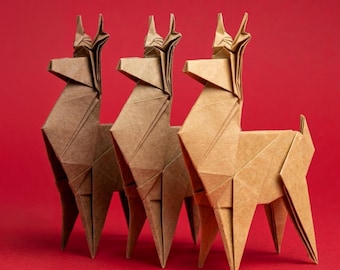 Könnte beinhalten: Drei Origami-Lamas aus braunem Papier, jedes mit ausgeprägten geometrischen Faltungen und scharfen, kantigen Linien. Die Figuren sind in einer Reihe angeordnet und zeigen verschiedene Nuancen von hellbraunem und beigem Papier vor einem roten Hintergrund.