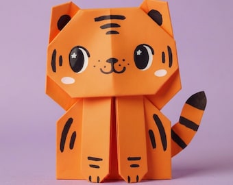 Könnte beinhalten: Eine orangefarbene Origami-Tigerfigur aus Papier mit schwarzen Streifen, großen schwarzen Augen mit weißen Sternreflexen, einer kleinen schwarzen Nase und einem Mund. Der Tiger hat spitze Ohren, zwei Vorderpfoten und einen gestreiften Schwanz.