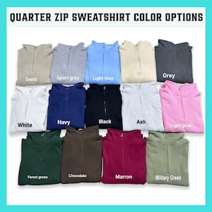 May include: A display of quarter-zip sweatshirts in various colors, including sand, sport grey, light blue, beige, grey, white, navy, black, ash, light pink, forest green, chocolate, maroon, and military green. The text "QUARTER ZIP SWEATSHIRT COLOR OPTIONS" is at the top.