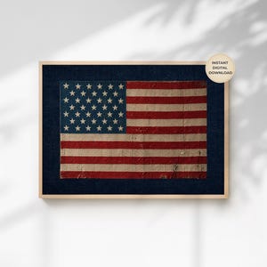 May include: A rectangular wall art print featuring a textured, weathered American flag design with red, white, and blue colors. The flag is set against a dark navy blue background within a light wood frame. A circular tag reads INSTANT DIGITAL DOWNLOAD.