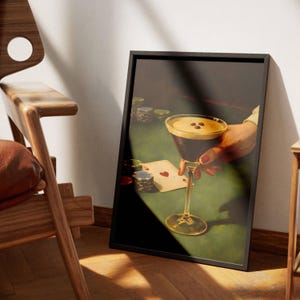 May include: A framed vertical art print depicting a dark-toned scene of a hand holding an espresso martini glass with three coffee beans on top. The composition includes a green poker table surface, stacks of colorful poker chips, and an ace card.