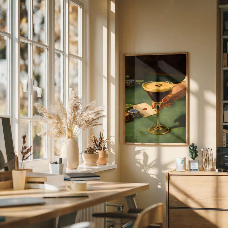 Vertical espresso martini wall art hanging in a sun-lit home office above a wooden desk, featuring pampas grass and window shadows for a warm, aesthetic digital download and coffee cocktail art vibe.