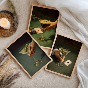 A collection of vintage martini prints and poker wall art series featuring espresso martini and dirty martini designs, styled with candles and pampas grass for a cohesive bar cart decor gallery wall set.