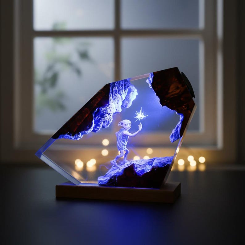May include: A decorative resin lamp featuring a character holding a glowing star. The lamp has a wooden base and a clear, angled resin body with blue and brown accents. The scene is illuminated with blue light.