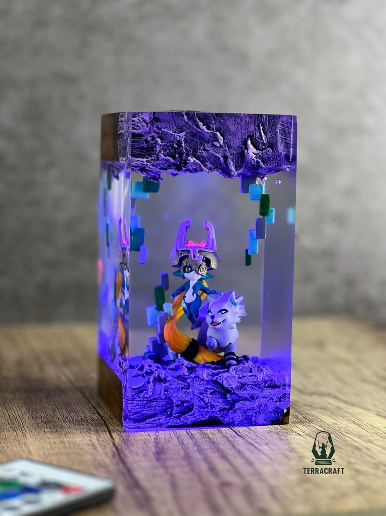 May include: A rectangular resin art piece with a wooden base, featuring two fantasy figures and a textured purple base. The figures are a fox-like creature with a long orange tail and a character with a purple mask. The piece is illuminated with blue light.