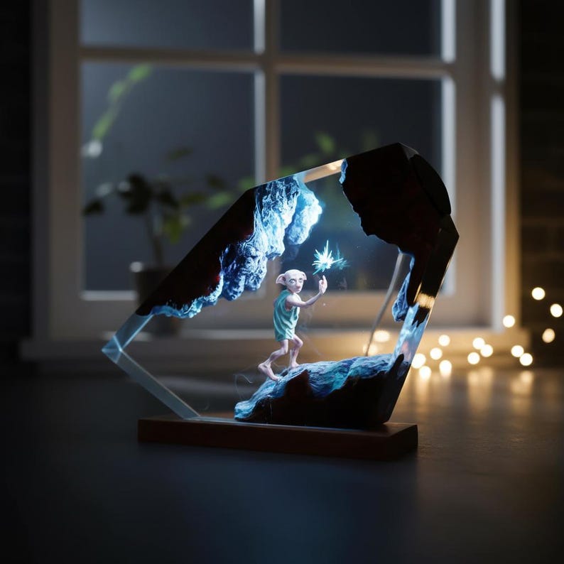 May include: A decorative resin sculpture featuring a character in a light blue outfit holding a glowing object. The sculpture is encased in a clear, geometric frame with blue and brown accents, set on a wooden base.