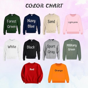 May include: A color chart displaying nine crewneck sweatshirts in various colors: forest green, navy blue, sand, light pink, white, black, sport gray, military green, red, and orange. Each sweatshirt has the color name printed on it.