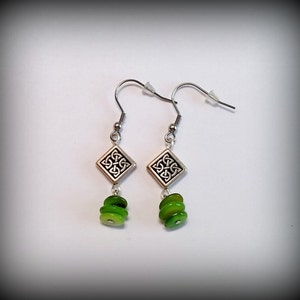 May include: Silver earrings with a Celtic knot design and three green glass beads.
