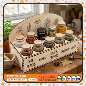 Może przedstawiać: Drewniany stojak na przyprawy z zakrzywioną górą i prostokątną podstawą. Zawiera kilka małych szklanych słoików z przyprawami, w tym płatki chili, kmin i czarny pieprz. Stojak ma grawerowane etykiety i dekoracyjne wzory kwiatowe.
