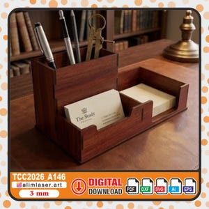 May include: A dark brown wooden desk organizer featuring a tall compartment for pens and pencils, a central slot holding business cards with the text The Study, and a lower section containing a stack of plain white paper notes for office supplies.