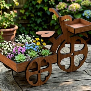 May include: A brown wooden bicycle-shaped planter featuring a heart-shaped seat and wheels with clover-shaped cutouts. The frame includes a front basket and a rear cargo bed filled with various small green succulents and tiny colorful flowers.