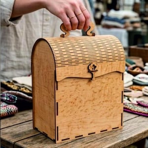 Può includere: Una scatola portaoggetti in legno chiaro con coperchio curvo a listelli e chiusura decorativa. La scatola presenta una maniglia sulla parte superiore, un pannello frontale piatto e giunti a incastro visibili sui lati, in legno naturale.