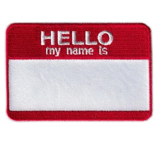 May include: A rectangular name tag patch with a red border and the words "HELLO my name is" embroidered in white. The center is a white rectangle for writing a name.