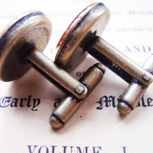 May include: A pair of antique gold cufflinks with a round, brown, and white cameo design.