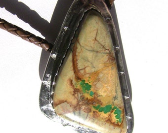 May include: A bolo tie with a silver setting and a large, triangular, green and brown stone.