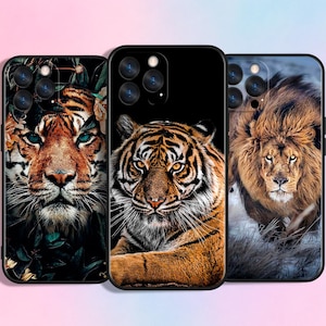Op de afbeelding: Drie smartphonehoesjes met afbeeldingen van wilde dieren. Het linkerhoesje toont een tijger tussen donker gebladerte. Het middelste hoesje toont een tijgerportret tegen een zwarte achtergrond. Het rechterhoesje toont een leeuw in de sneeuw.