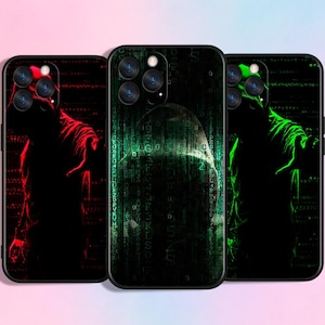 Könnte beinhalten: Drei Handyhüllen mit einem Design einer Kapuzenfigur. Die linke Hülle hat eine rote Figur, die mittlere Hülle eine grüne Figur und die rechte Hülle eine grüne Figur. Jede Hülle hat einen schwarzen Hintergrund mit einem Matrix-Muster.