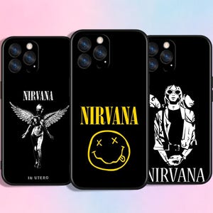 Op de afbeelding: Zwarte telefoonhoesjes met Nirvana bandontwerpen. Eén hoesje toont de bandnaam met een engelafbeelding, een ander de iconische smiley en de derde een illustratie van een bandlid.
