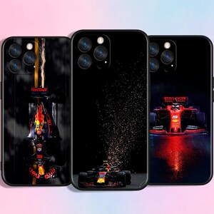 Pode incluir: Três capas pretas para smartphone com temas de corrida de Fórmula 1. A capa esquerda mostra um carro de corrida visto de cima com faíscas. A central exibe um carro com um rastro de faíscas. A direita mostra um carro vermelho com o número 5.