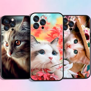 May include: Three phone cases with cat designs. One case features a gray cat with orange eyes, another a white cat with blue eyes and red leaves, and the third a ginger cat with blue eyes.