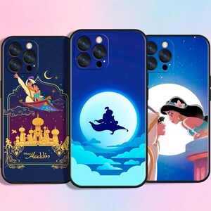 Peut inclure: Trois coques de téléphone avec des motifs d'Aladdin. Les coques ont un fond bleu foncé avec des illustrations d'Aladdin, Jasmine et le tapis magique. Une coque montre Aladdin et Jasmine sur un tapis magique, une autre montre Aladdin volant devant une lune.