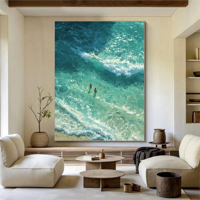 Puede incluir: Gran lienzo rectangular que representa una vista a&eacute;rea de las olas del oc&eacute;ano en tonos turquesa y aguamarina. Dos figuras nadan en el agua. La obra de arte se exhibe en un sal&oacute;n moderno.
