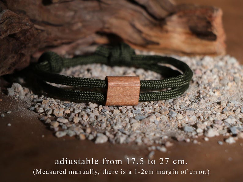 May include: An olive green rope bracelet with a wooden rectangular clasp. The bracelet is adjustable from 17.5 to 27 cm. The text on the image says "adiustable from 17.5 to 27 cm."