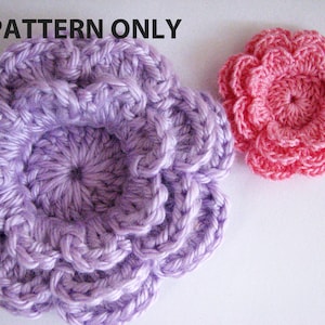 May include: Two crocheted flowers, one in a light purple and one in a bright pink. The flowers are made with a single crochet stitch and have a ruffled edge.