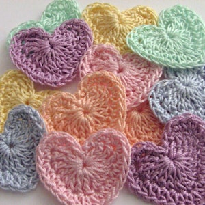 May include: A collection of crocheted hearts in various pastel colors, including light blue, lavender, pink, and yellow.
