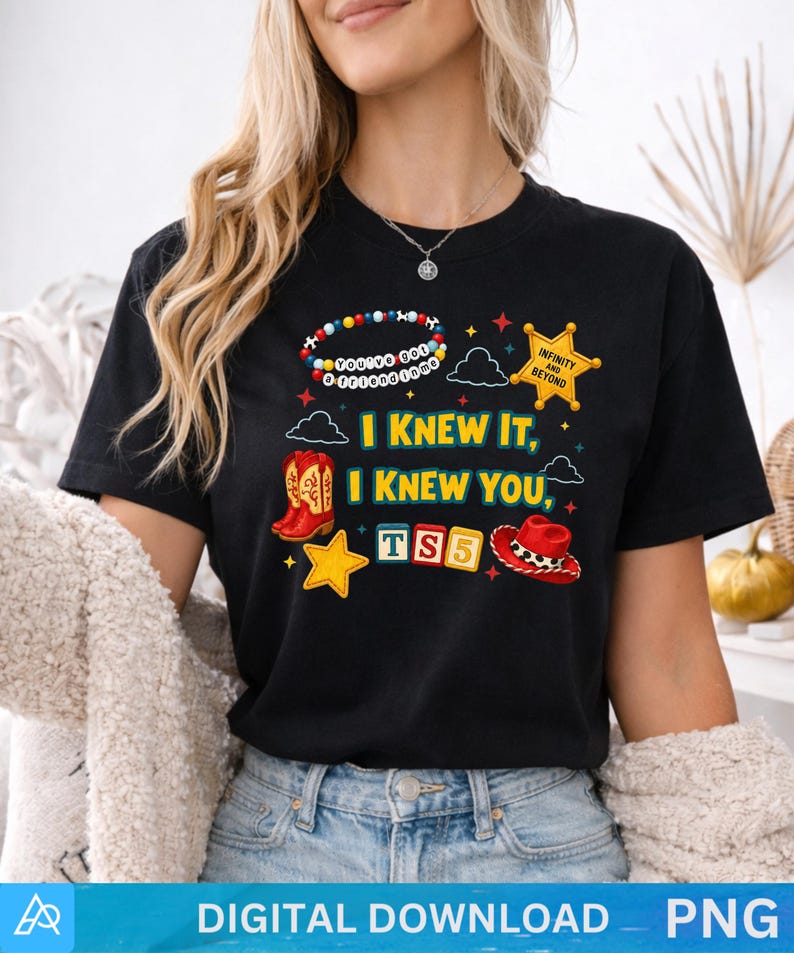 K&ouml;nnte beinhalten: Ein schwarzes kurz&auml;rmeliges T-Shirt mit einem Grafikdruck, der den Text "I KNEW IT, I KNEW YOU", ein Perlenarmband mit "YOU'VE GOT A FRIEND IN ME", einen Sheriffstern mit "INFINITY AND BEYOND", Cowboystiefel, einen Cowboyhut und "TS5"-Bl&ouml;cke zeigt.