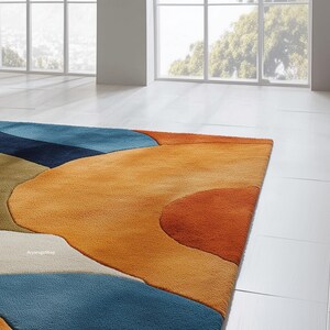May include: A colorful area rug with an abstract design. The rug features a combination of blue, orange, and green hues in a flowing, organic pattern. The rug is made of a soft, plush material and is designed for indoor use.