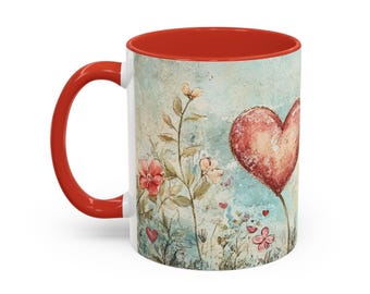 May include: A white ceramic mug with a red handle and interior. The mug features a watercolour design of a red heart, flowers, and foliage against a light blue background. The mug is a standard 325 ml size.
