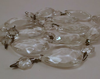 May include: A collection of clear crystal prisms with silver accents. The prisms are faceted and have a variety of shapes, including teardrop, oval, and round. The prisms are strung together with silver wire.