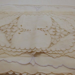 May include: A stack of white lace doilies with scalloped edges and intricate floral designs.