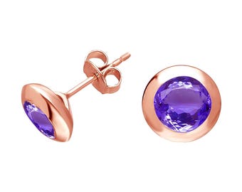 Peut inclure: Boucles d'oreilles à clous en or rose avec des pierres précieuses violettes rondes serties en lunette. Une boucle d'oreille est inclinée, montrant la tige et le dos. L'autre boucle d'oreille est de face, affichant la couleur et la taille de la pierre.