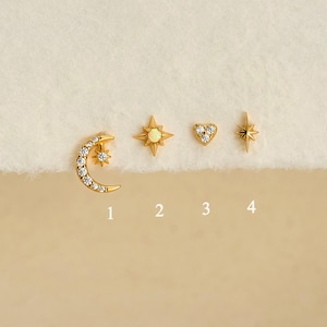 May include: Four gold-tone stud earrings labeled 1 through 4. Item 1 is a crescent moon with a small star, 2 is a star with an opal center, 3 is a heart with three stones, and 4 is a four-pointed star. The text Gleamy Day is at the bottom.