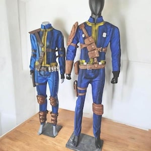 May include: Two mannequins dressed in blue and yellow cosplay outfits. The outfits include jackets, pants, belts, and pouches. The costumes have brown accents and are displayed on a wooden surface.