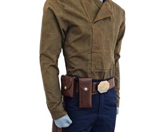 May include: A brown long-sleeve jacket with a mandarin collar and a matching brown belt with a cream-colored buckle. The outfit includes a brown holster and brown pouches attached to a brown belt. The pants are navy blue with a red stripe.