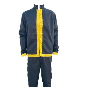 May include: A black tracksuit with yellow detailing. The jacket features a high collar and a yellow stripe down the front and on the sleeves. The trousers are plain black.