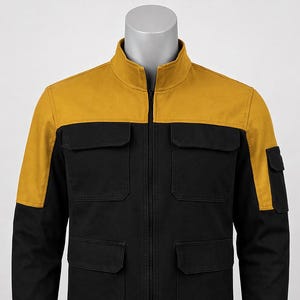 May include: A black jacket with a mustard yellow yoke and shoulder accents. The jacket has a stand-up collar, a zipper closure, and four front pockets. The sleeves are long, and the jacket is displayed on a mannequin.