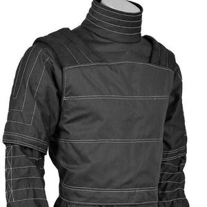 May include: Black protective jacket with white stitching details. The jacket features a high collar, padded shoulders, and reinforced panels. The design includes horizontal and vertical stitching patterns for added durability and style. The jacket is likely for protection.