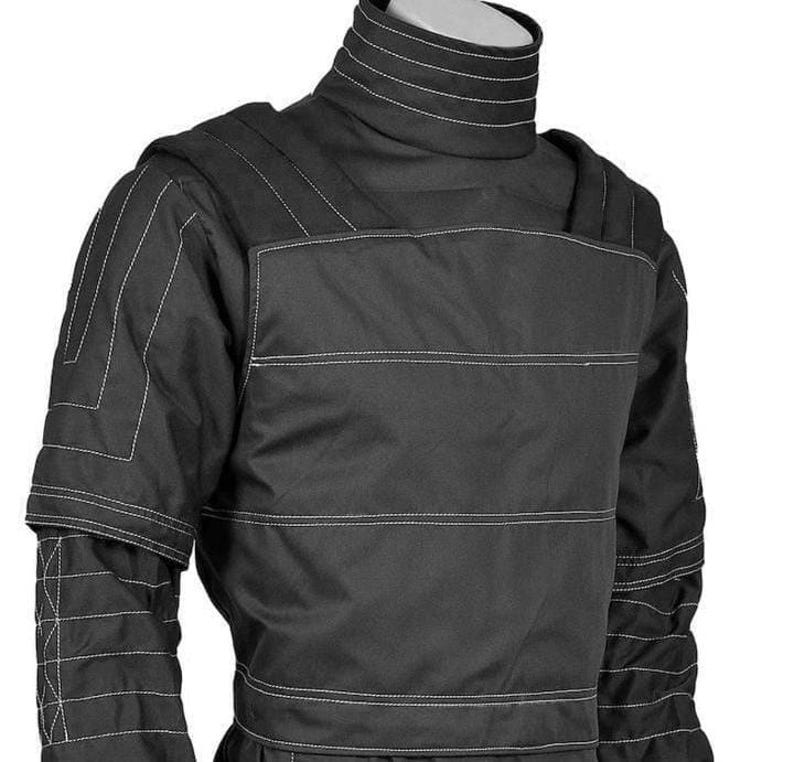 May include: Black protective jacket with white stitching details. The jacket features a high collar, padded shoulders, and reinforced panels. The design includes horizontal and vertical stitching patterns for added durability and style. The jacket is likely for protection.