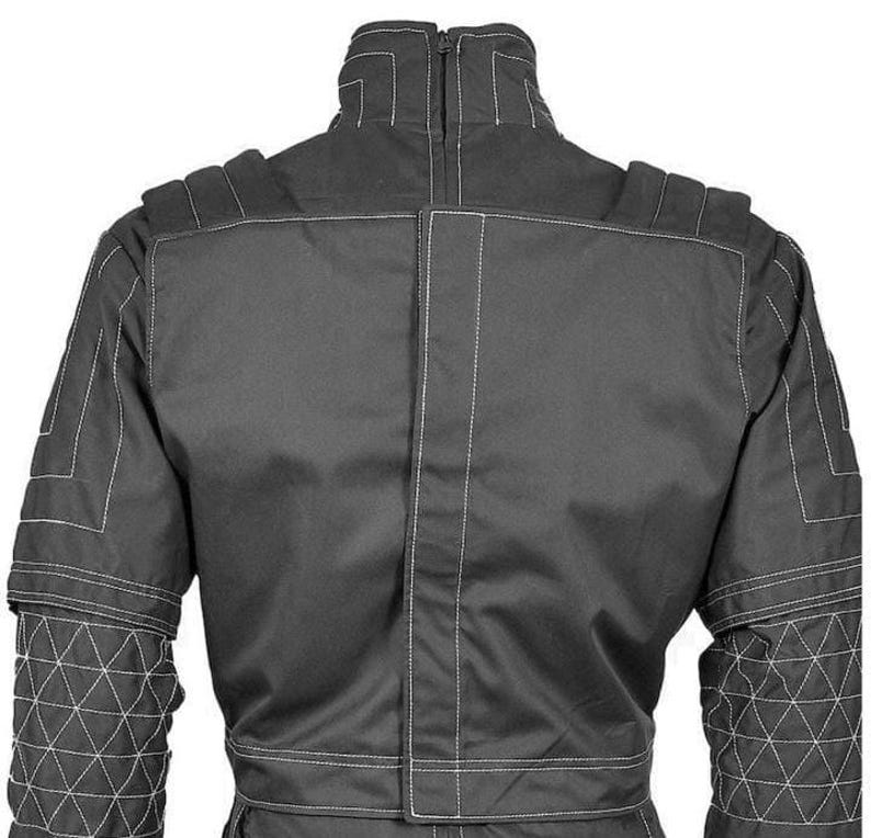 May include: A dark gray racing suit with white stitching. The suit features a high collar, padded shoulders, and geometric patterns on the sleeves. The back of the suit is visible, showcasing the vertical and horizontal seams.