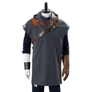 May include: A gray hooded tunic with brown leather accents and a shoulder strap. The costume includes a brown leather glove and wrist cuff. The outfit is displayed on a mannequin.