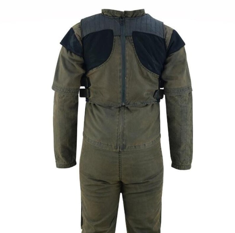 K&ouml;nnte beinhalten: Olivgr&uuml;ner Overall mit schwarzen Schulter- und Brustakzenten. Er verf&uuml;gt &uuml;ber einen durchgehenden Rei&szlig;verschluss, verstellbare Riemen und verst&auml;rkte Schulterpolsterung. Der Overall ist auf Langlebigkeit und Schutz ausgelegt.