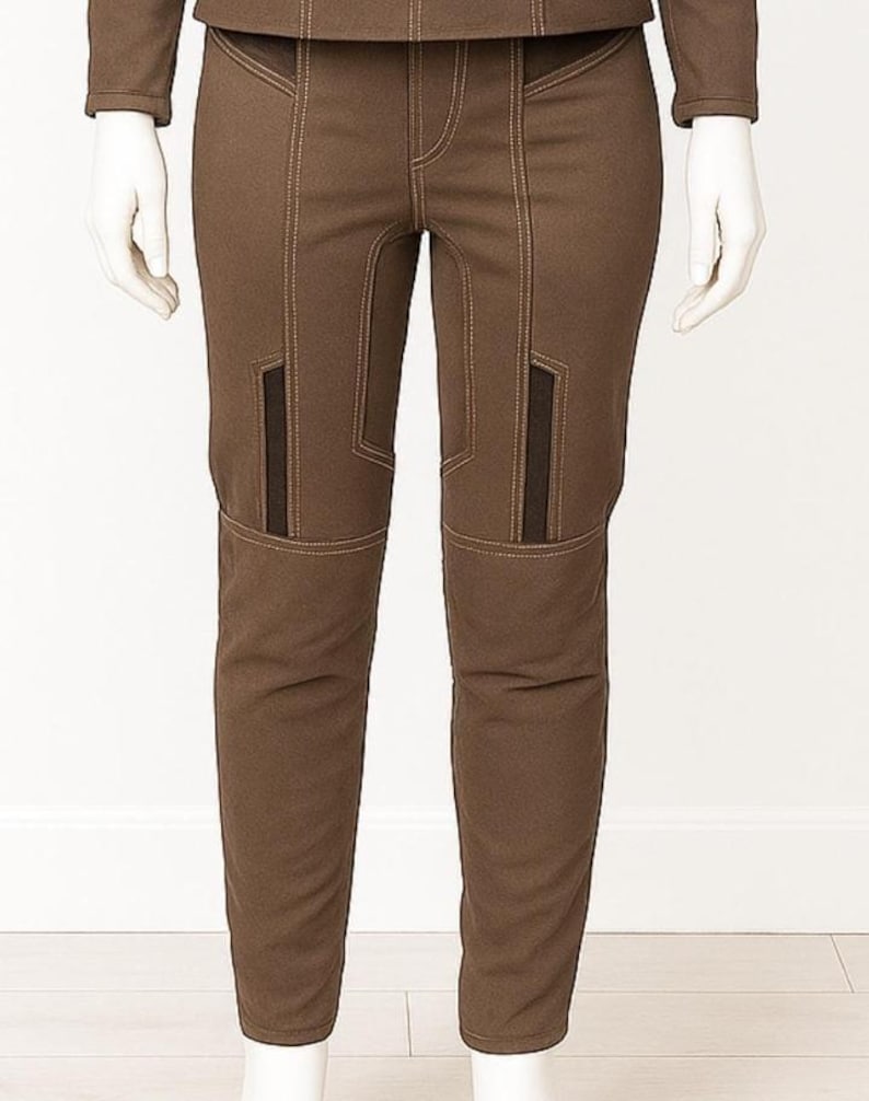 May include: Brown trousers with contrasting stitching and dark brown panels on the knees. The trousers are displayed on a mannequin. The trousers have a tailored fit and a classic design, suitable for various occasions.