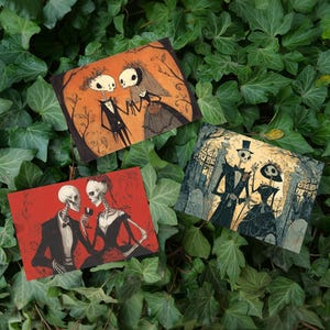 Puede incluir: Tres impresiones artísticas rectangulares que representan parejas de esqueletos en varias escenas. Una impresión muestra a una pareja tomados de la mano, otra a una pareja brindando con vino y la tercera a una pareja en un cementerio. Las impresiones tienen un tema gótico.