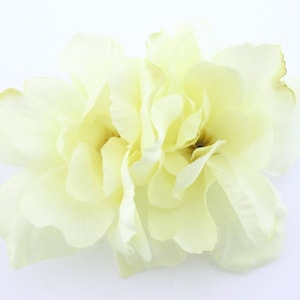 May include: Two pale yellow artificial flowers with multiple layers of petals.