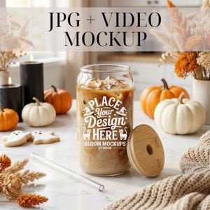 May include: A clear glass can-shaped tumbler filled with iced coffee, featuring a white graphic print that reads PLACE YOUR DESIGN HERE BLOOM MOCKUPS STUDIO with witch hats and cats. Includes a bamboo lid and a clear glass straw.